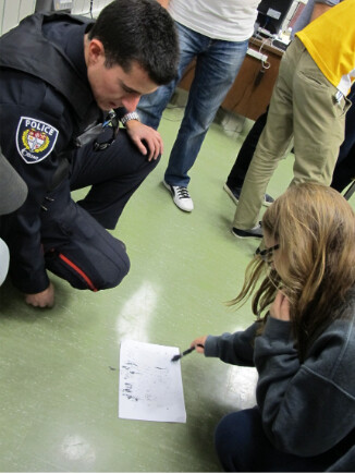 Picture of student with an emergency service worker looking at a piece of paper